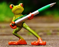 Frosch hält Kugelschreiber